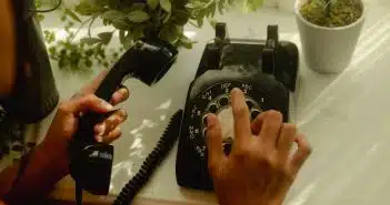 person holding black rotary telephone