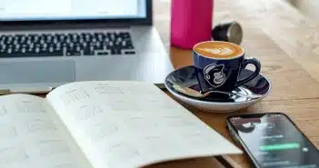 a coffee cup and a pen on a desk
